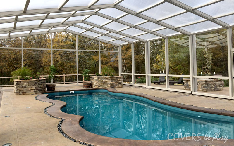 Interior view of closed pool enclosure with frosted windows and trees surrounding the infrastructure