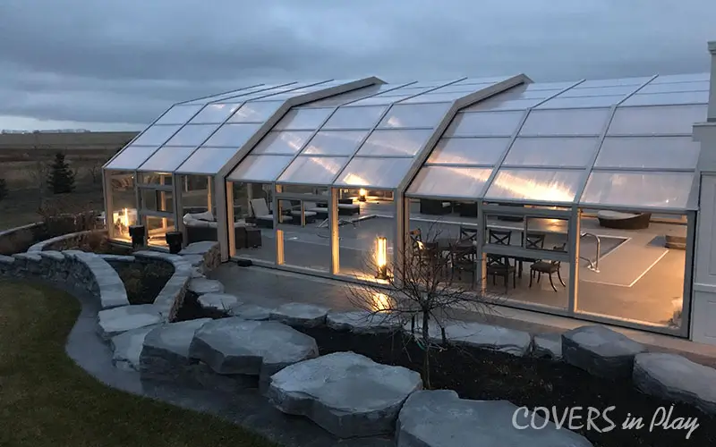 Exterior complete view of backyard pool enclosure at night