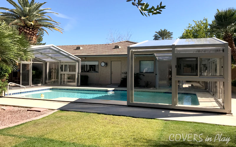 Side exterior view of opened residential pool enclosure in backyard home