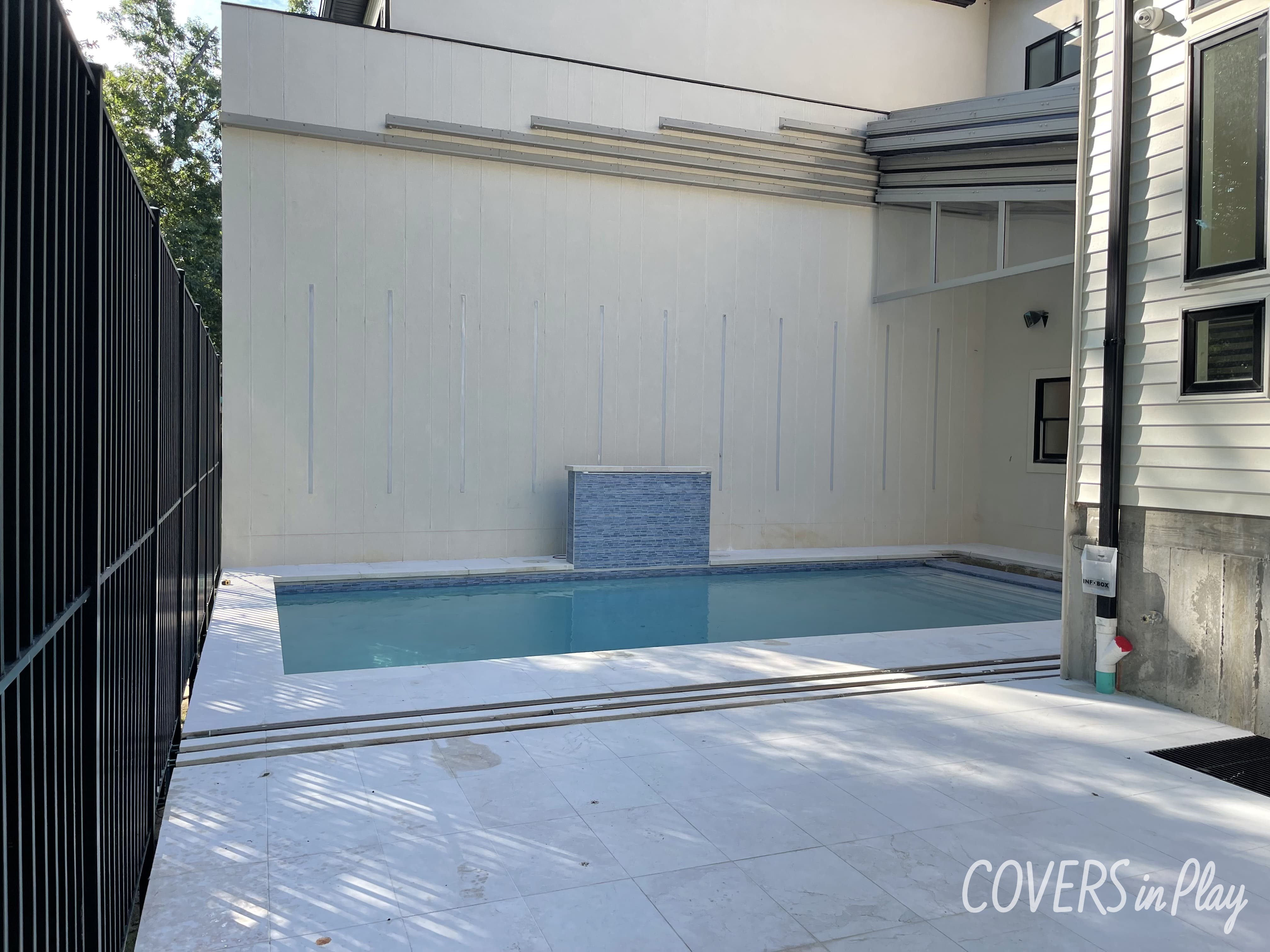 Retractable roof over a pool in Lakewood, NJ, leaning on the house,making for a seamless transition from indoor to outdoor living.