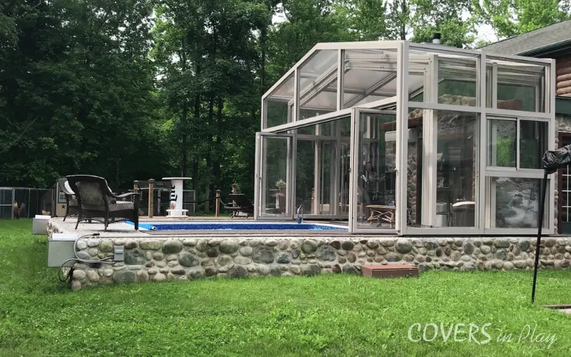 Exterior side view of opened swimming pool enclosure surrounded by trees in Trenton, NJ