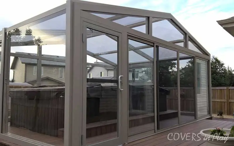 Rear view of pool enclosure with bi-fold doors open at a family backyard in Trent, NJ.