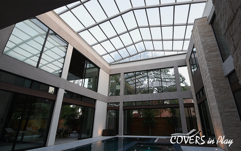 Retractable roof over a large home atrium in Houston, TX, letting the sunlight in and keeping the weather out.