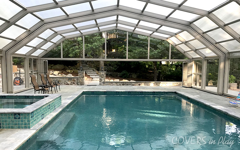 Interior view of swimming pool dome in Kinnelon, NJ, featuring bi-fold doors opening to a landscape of forestry
