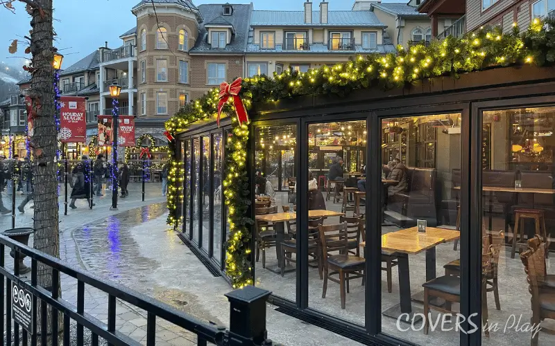 Side view of commercial Blue Mountain patio enclosure with bi-fold doors and festive Christmas lights